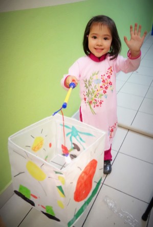 Một thiếu nhi vừa tự làm lồng đèn ở lớp thủ công, trường Về Nguồn. Hình: UGVF.